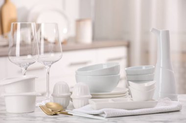 Farklı beyaz bulaşık takımları, bardaklar ve çatal bıçaklar.