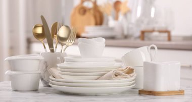 Farklı beyaz bulaşık takımları, bardaklar ve çatal bıçaklar.