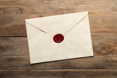 Tahta masanın üzerinde balmumu mühür olan zarf, üst manzara.