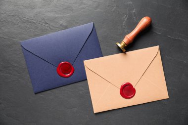 Balmumu mühürlü zarflar ve siyah masa üzerinde damga, düz yatıyordu.