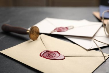 Balmumu mühürlü zarflar ve siyah masa üzerinde damga, yakın çekim