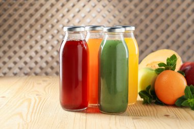 Cam şişelerdeki lezzetli sıvılar, taze malzemeler ve kapalı alandaki ahşap masa üzerindeki nane şekeri.