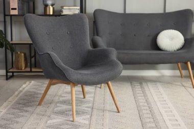 Şık gri koltuk, kanepe ve raf ünitesi içeride. İç tasarım