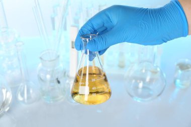 Masada kirli su şişesi olan bir bilim adamı bulanık arka planda, yakın plan