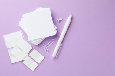 Menekşe arka planda farklı beyaz kırtasiye malzemesi, düz. Metin için boşluk