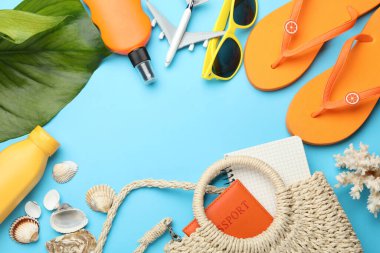 Yaz tatili zamanı. Pasaport, defter, oyuncak uçak, yeşil yaprak ve açık mavi arka planda plaj aksesuarları. Metin için boşluk