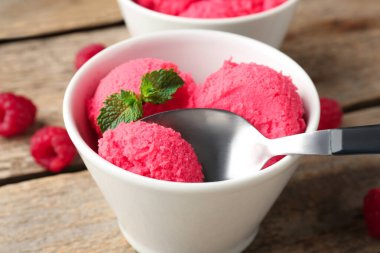 Lezzetli ahududu şerbeti, ahşap masada kaşıkla nane şekeri, yakın plan.