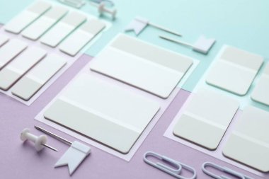 Renk arkaplanı üzerine beyaz yapışkan sekmeler ve diğer kırtasiyeler, yakın plan
