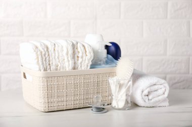 Tuğla duvarın yanındaki masada bir sürü bebek aksesuarı var.