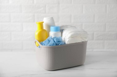 Tuğla duvarın yanındaki masada çok farklı bebek banyosu gereksinimleri var.