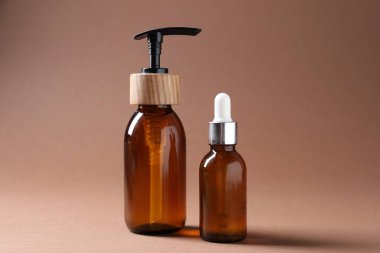 Terfi ettim. Kahverengi arka planda kozmetik ürünleri şişeleri, yakın plan