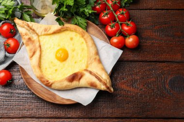 Peynirli, yumurtalı, domatesli, maydanozlu, ahşap masadaki lezzetli khachapuri. Metin için boşluk