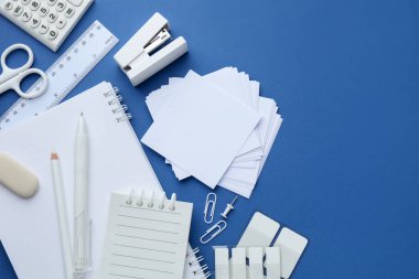 Mavi arka planda beyaz kırtasiye malzemesi, düz. Metin için boşluk