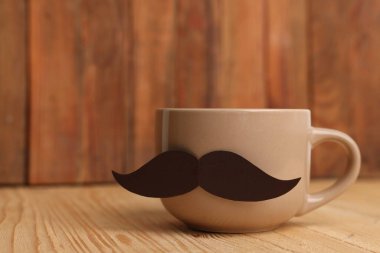 Babalar Günün kutlu olsun. Tahta masadaki bıyıklı kupa, yakın plan. Metin için boşluk