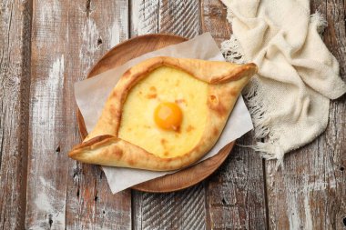 Tahta masadaki peynirli ve yumurtalı leziz khachapuri.
