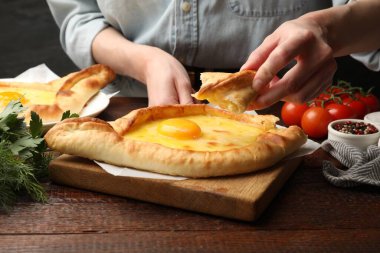 Ahşap masada nefis khachapuri yiyen kadın, yakın plan.