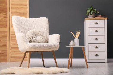 İçinde yastık, sehpa ve çekmeceler olan çağdaş bir koltuk. İç tasarım