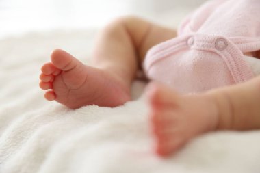 Sevimli yeni doğmuş bebek yatakta uzanıyor, yakın plan.