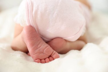 Sevimli yeni doğmuş bebek yatakta uzanıyor, yakın plan.