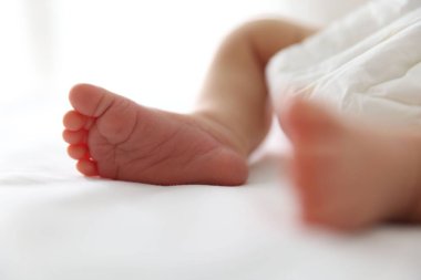 Sevimli yeni doğmuş bebek, yatakta uzanıyor, yakın plan.