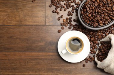 Aromatik kahve fincanda, fasulye de tahta masada, düz yerde. Metin için boşluk