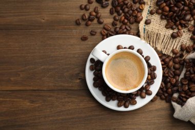 Aromatik kahve fincanda, fasulye de tahta masada, düz yerde. Metin için boşluk