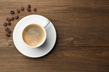 Aromatik kahve fincanda, fasulye de tahta masada, düz yerde. Metin için boşluk