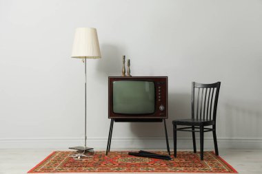 Retro TV tribünde, siyah sandalye ve lamba beyaz duvarın yanında. Kullanılmış eşyalar