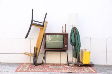 Tribünde Retro TV ve dışarıdaki beyaz duvarın yanında kullanılan diğer şeyler.