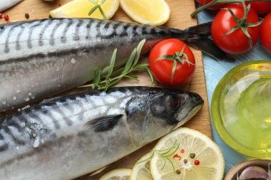 Taze çiğ uskumrular ve baharatlar açık mavi ahşap masada, düz yerde. Deniz ürünleri lezzetleri.
