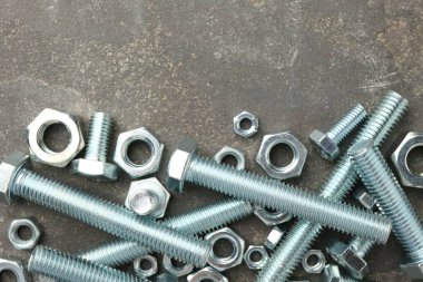 Metal civatalar ve fındıklar gri masada, düz yatıyordu. Metin için boşluk