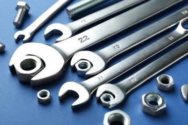 Mavi arka planda metal anahtarlar, fındıklar ve cıvata, yakın plan