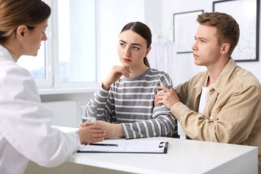 Tüp bebek (tüp bebek). Üreme kliniğine yaptığı ziyarette üzgün çifti destekleyen doktor