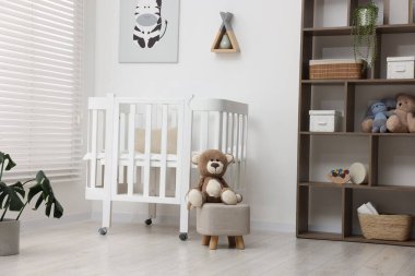 Bebek odasında rahat bir beşik ve oyuncak ayı var. İç tasarım