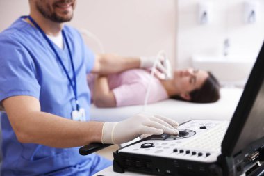 Sonograf klinikte kadının tiroid bezini ultrason taraması yapıyor.