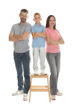 Güzel aile beyaz arka planda birlikte poz veriyor.