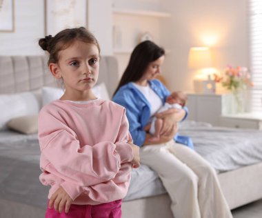 Kıskanç küçük kız, annesinin yeni doğmuş bebekle evde vakit geçirmesine üzülüyor.