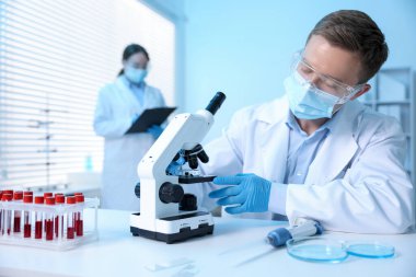 Tıbbi analiz. Laboratuvarda mikroskopla çalışan bilim adamı, seçici odaklanma