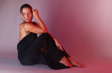 Renkli arka planda neon ışıklarla poz veren güzel bir kadın. Metin için boşluk