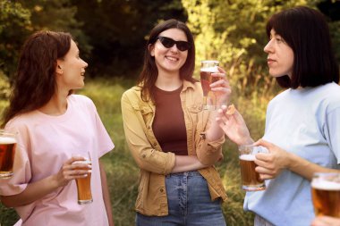 Bir grup mutlu arkadaş dışarıda bira içip eğleniyorlar.