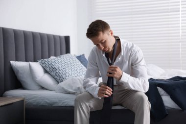 Üzgün genç adam evde hazırlanıyor.