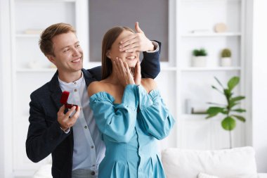 Evlilik teklifi yapıyor. Nişan yüzüğüyle gülümseyen adam evde kız arkadaşına sürpriz yapıyor. Metin için boşluk