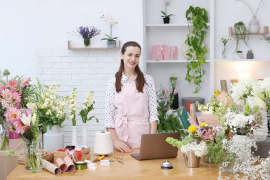 Dükkandaki ahşap masada çalışan profesyonel bir çiçekçi.