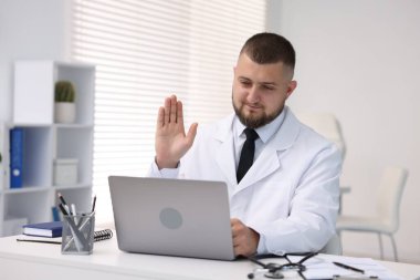 Klinikte bilgisayarla online danışmanlık yapan bir doktor