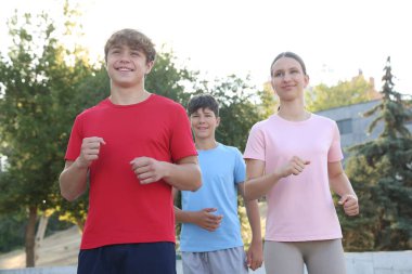 Parkta koşan bir grup genç. Açık havada eğitim.