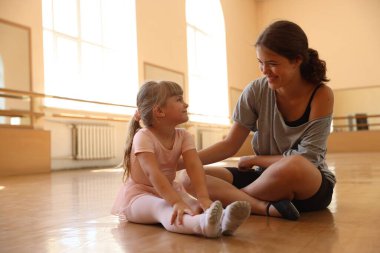 Dans sınıfında küçük bir kızla çalışırken mutlu bir bale öğretmeni.
