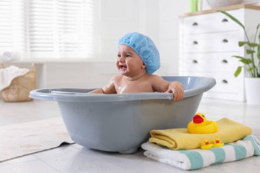 Evde şapkalı şirin bir bebek banyo yapıyor.