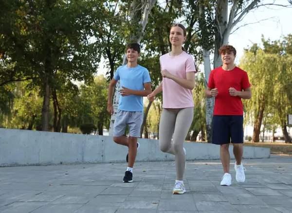 Parkta koşan bir grup genç. Açık havada eğitim.