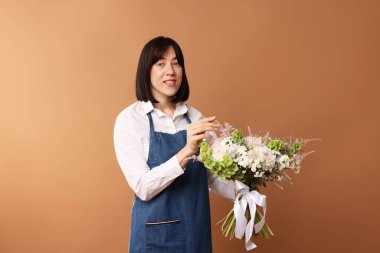 Koyu bej arka planda güzel çiçek buketi olan bir çiçekçi.