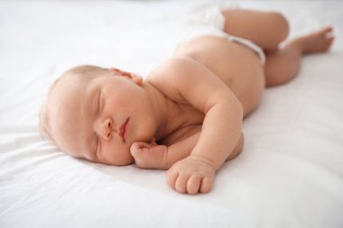 Yeni doğmuş şirin bebek evde yatakta uyuyor.